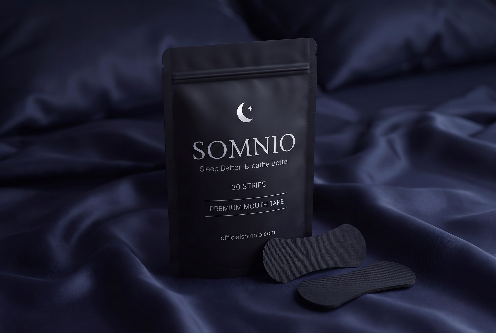 SOMNIO branded pouch and mouth tape strips on dark navy silk under moonlight